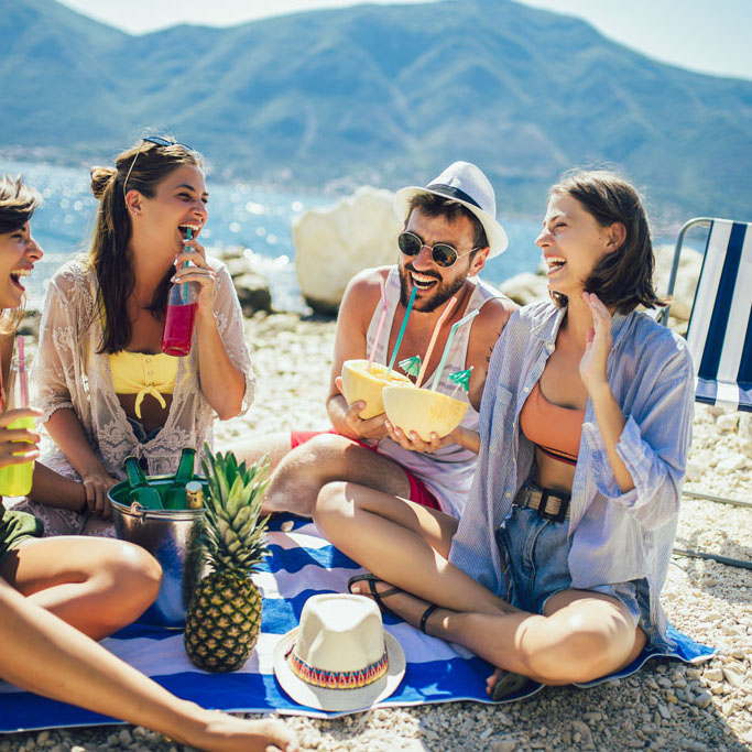 Young friends having fun at the beach on a sunny day. Party time.