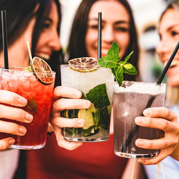 Group of happy friends toasting and drinking fancy cocktails at bar terrace-Three Young girls drink mojito and clinking glass together at pub enjoying happy hour at summer party- Life Style concept